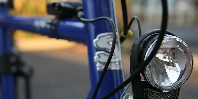 Närbild på cykellampa monterad på blå cykelram