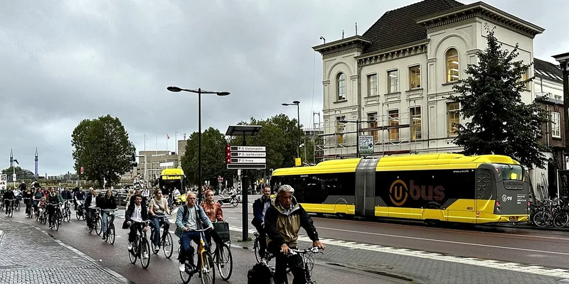 Cykelpendlare i stadstrafik med buss i bakgrunden