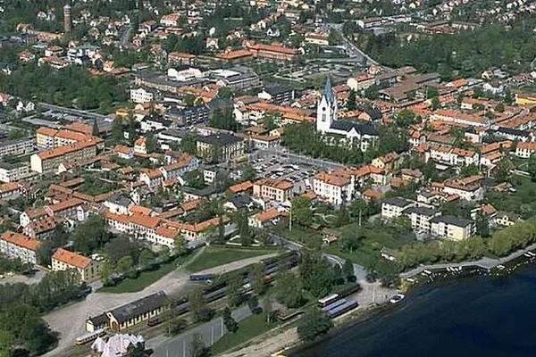 Flygfoto över stad vid sjö med kyrka, troligen Ludvika
