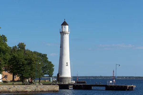 Vit fyr på stenpir i Karlskrona med hav i bakgrunden