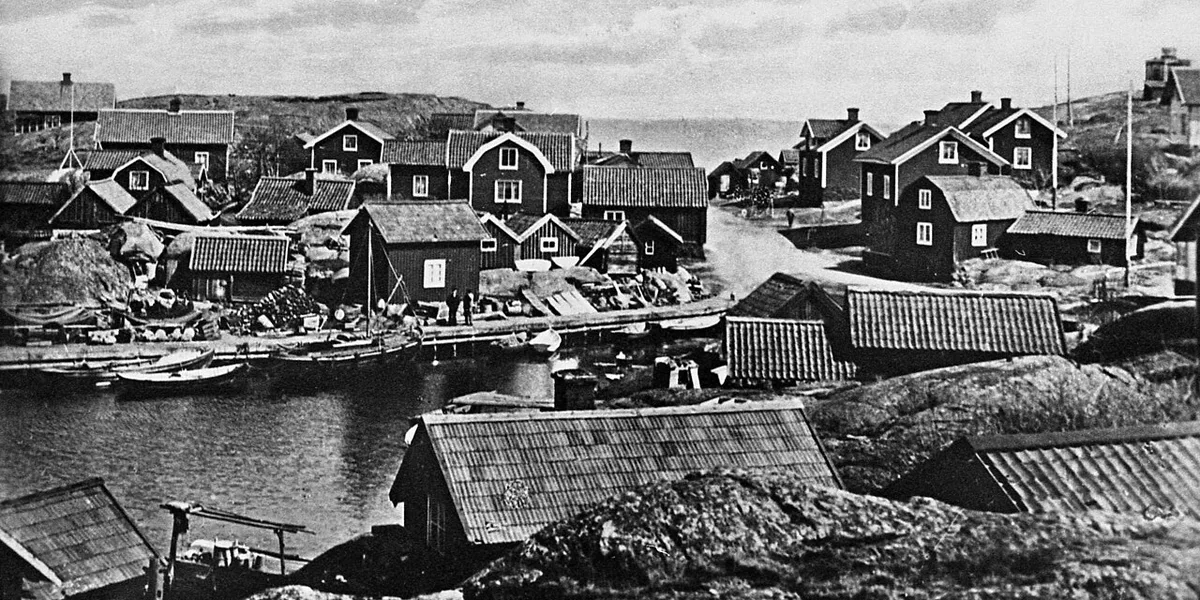 Historiskt svartvitt foto av kustfiskeläge med sjöbodar