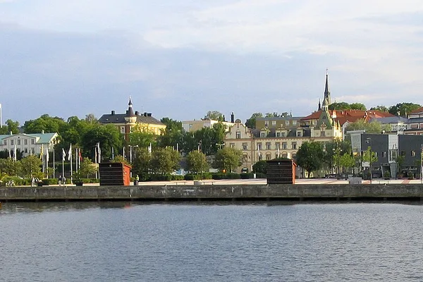 Oskarshamns stadsbild sedd från havet med kyrktorn och historiska byggnader längs kajen